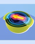 Stacked colorful nesting bowls and measuring spoons on a blue background.