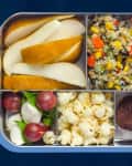 Lunchbox with pear slices, quinoa salad, mozzarella with grapes, popcorn, and chocolate cookies.