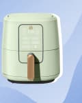 Green air fryer with digital display and brown handle on a blue abstract background.