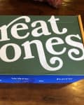 Green and blue Great Jones box on a wooden table.