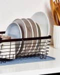 Black dish rack on counter with dishes drying
