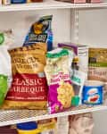 Assorted snack bags and pantry items on white wire shelving, including chips and brown sugar.