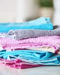 Stack of colorful folded kitchen towels on a countertop.