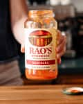 Someone holding an empty jar of Rao's Marinara