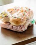 Someone pulling plastic tab from hamburger buns