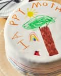 someone is drawing on a happy mothers day cake with edible markers