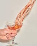 wine flowing out upwards of a coupe glass