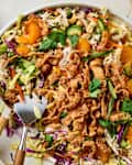 overhead shot of chopped chicken salad with sesame dressing in a large serving bowl