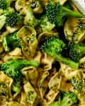 Tortellini with broccoli and pesto sauce in a white bowl.