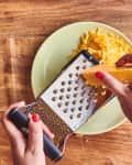 someone grating cheese