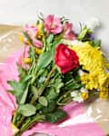 A Trader Joe's flower bouquet next to a vase of water