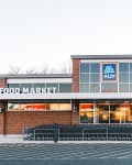 Brick exterior of Aldi food market with shopping carts lined up outside.