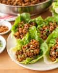Chicken lettuce wraps, garnished with scallions, on a plate