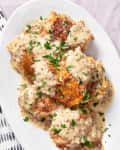 Platter filled with chicken thighs in a creamy French mustard sauce cooking in a slow cooker