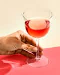 A glass of rose on a pink surface