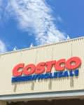 Costco Wholesale storefront with large red and blue signage under a clear sky.