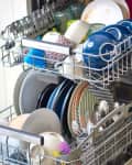 Open dishwasher with neatly arranged dishes, cups, and utensils.