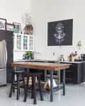 An industrial kitchen with black wood cabinets and a blue standalone pantry.