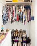 Organized closet with colorful clothes on hangers, shoes neatly arranged below, and boxes on the shelf above.