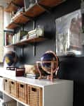 Home office with wall shelves, globes, wicker baskets, and a basketball.