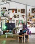Eclectic living room with colorful decor, wall art, bookshelves, a pool table, and a large disco ball.