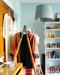 A bedroom featuring a clothing rack and a tall shoe rack
