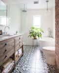 A bathroom with a black and white pattern on the tiled flooring.