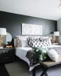 Several patterned throw pillows on top of a bed in a sun-filled bedroom
