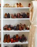 A six-tier shoe storage cabinet filled with different styles of shoes