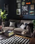 black living room with lots of wall art and black and white striped area rug