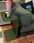 Haworth side table topped with candle and water bottle beside sofa.
