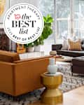 Sunny living room with grey sectional sofa and best list seal in upper left