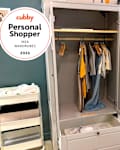 Wardrobe with hanging clothes, a drawer, and a storage cart with shoes, set in a bright, modern space.