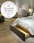 Arden upholstered storage bed at Crate and Barrel store with personal shopper seal in upper left