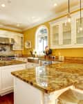 Spacious kitchen with yellow walls, granite countertops, white cabinets, and stainless steel appliances.