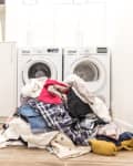 Dirty clothes pile up on the floor ready to be put in the washing machine