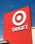 Red Target store sign with logo against a clear blue sky.