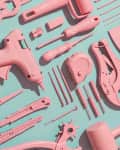 Assorted pink tools including scissors, glue gun, and screwdriver on a teal background.