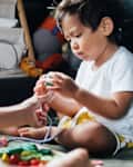 Asian little boy playing toy with his mother