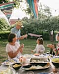 Family applauding at senior man and girl dancing during garden party