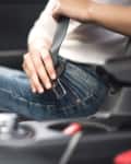 Passenger woman fastening seat belt in the car, safety concept