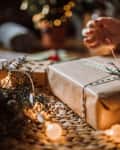 Young Woman Wrapping Christmas Gifts In Living Room