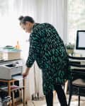 businesswoman using computer printer at home office.
