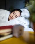 Young woman sleeping peacefully on her bed at home.