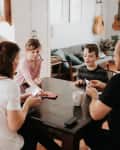Family of four playing cards in kitchen
