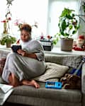 Woman relaxing on sofa with digital tablet