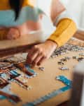 two people putting a jigsaw puzzle together