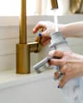 Woman filling up a reusable water bottle at the sink