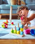 Beautiful toddler child girl playing with toys on the carpet