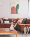 Living room with rust-colored suede sofa, wood coffee table